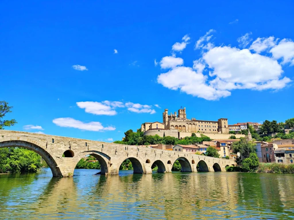 An ancient bridge leads to a beautiful hilltop castle.