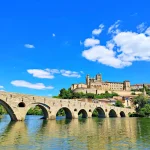 An ancient bridge leads to a beautiful hilltop castle.