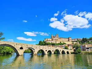 An ancient bridge leads to a beautiful hilltop castle.